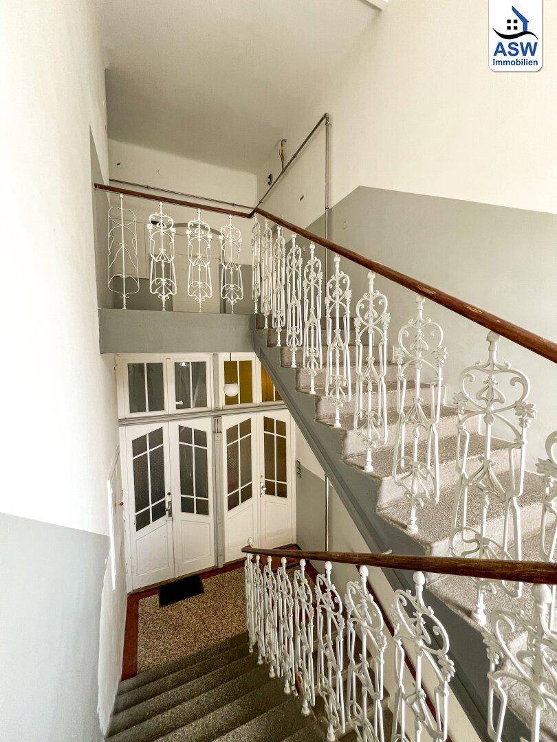 Historisches Treppenhaus mit kunstvollen Geländern und Terrazzostufen in einem Altbau.