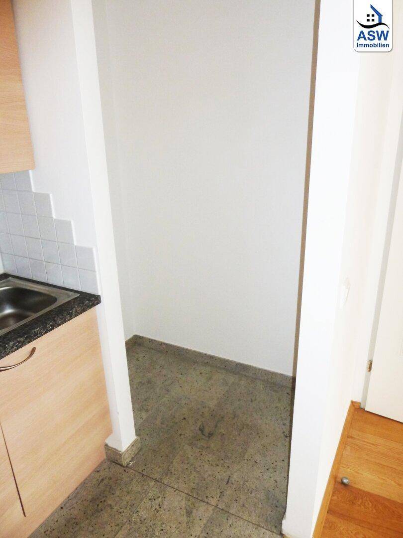 Kleiner Abstellraum mit Fliesenboden, ideal für zusätzlichen Stauraum neben der Küche.