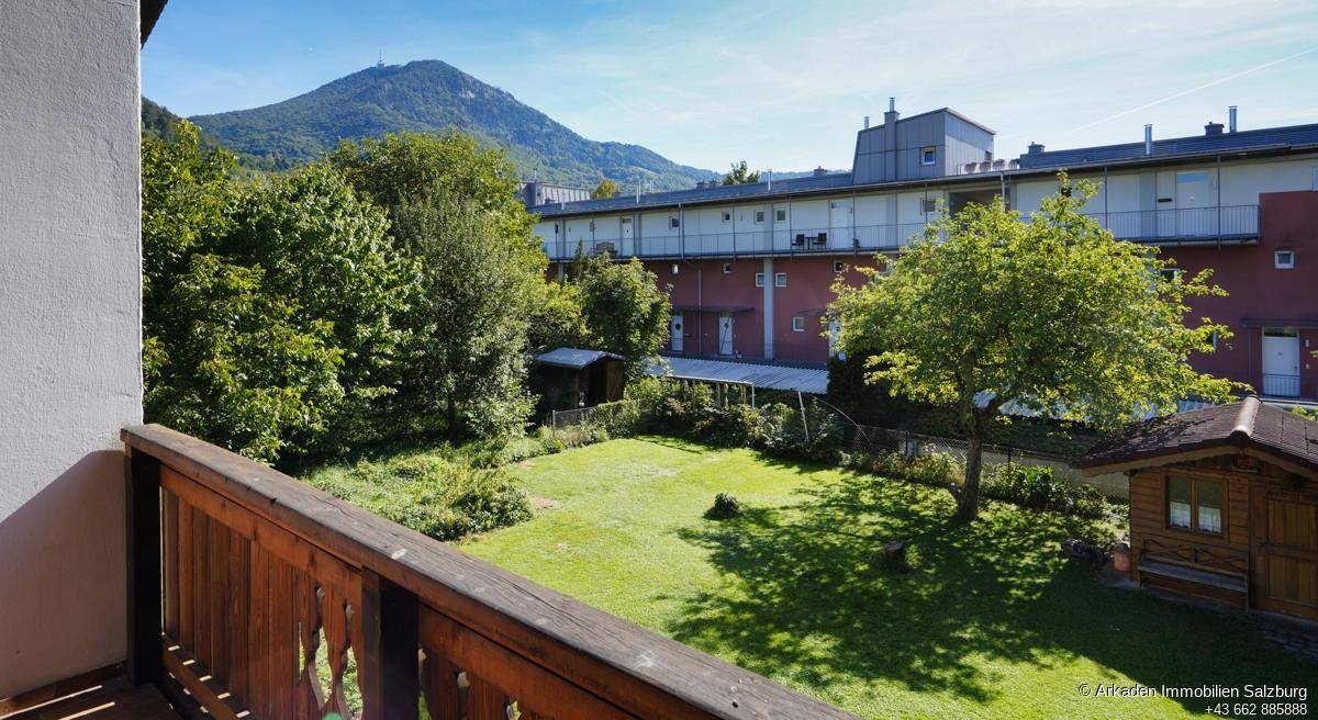 Geräumiger Balkon mit weitem Blick über den Garten und die umliegende Berglandschaft.