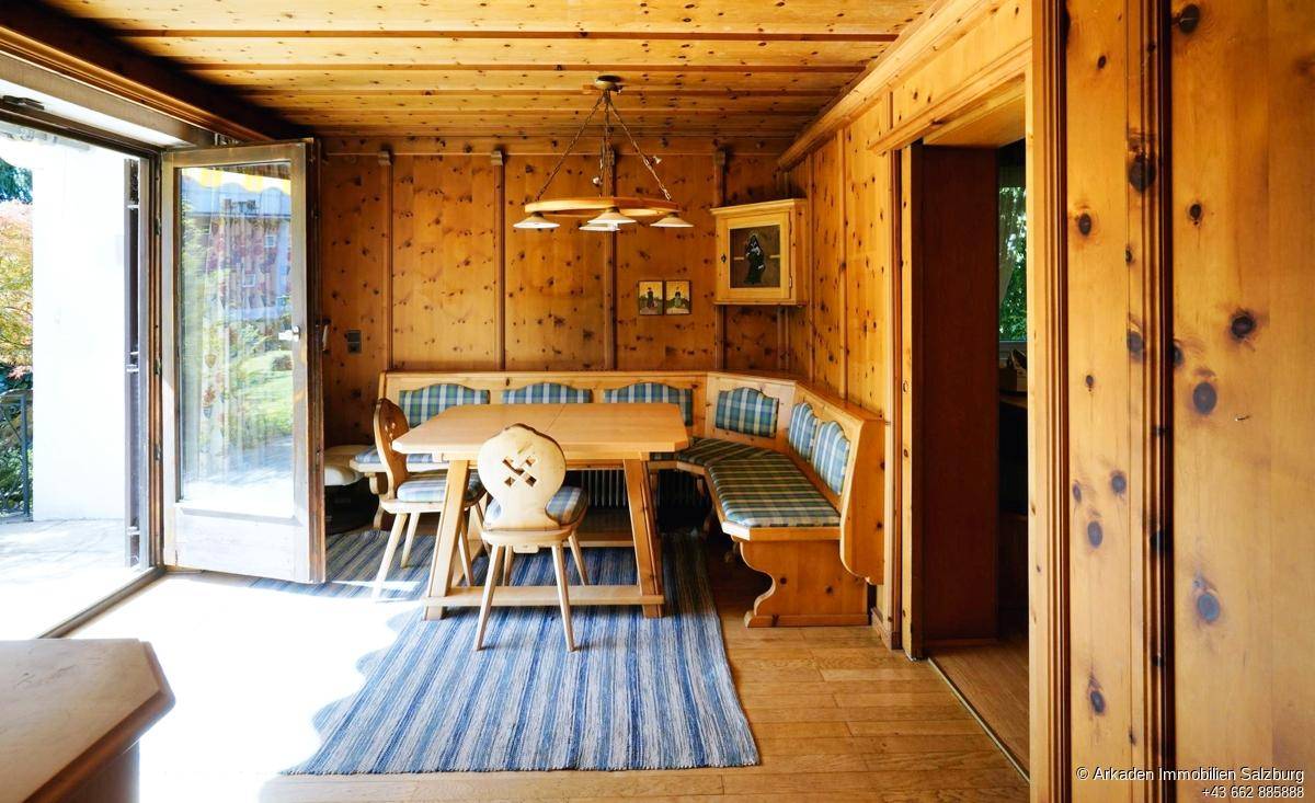 Traditioneller Essbereich mit Holztäfelung, Eckbank und Zugang zur Terrasse.