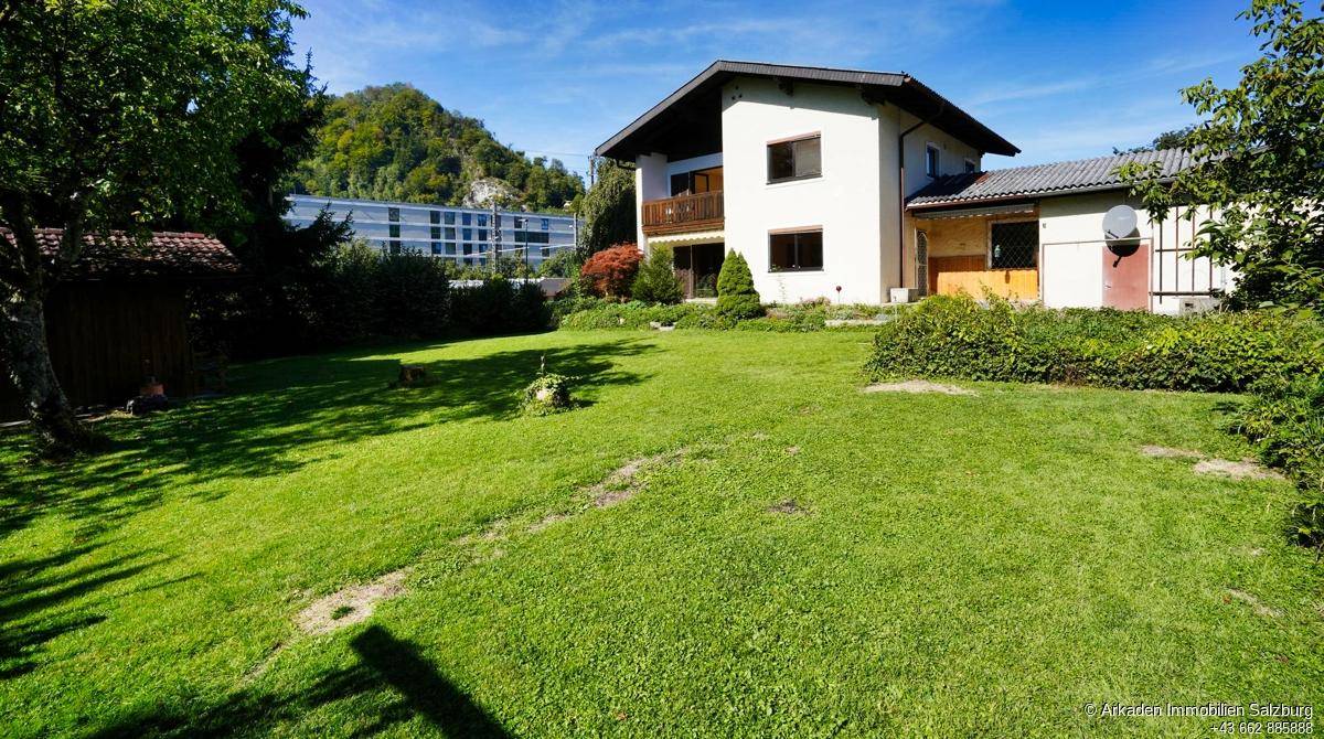 Weitläufiger Garten mit Rasenfläche und Blick auf die umliegende Berglandschaft.