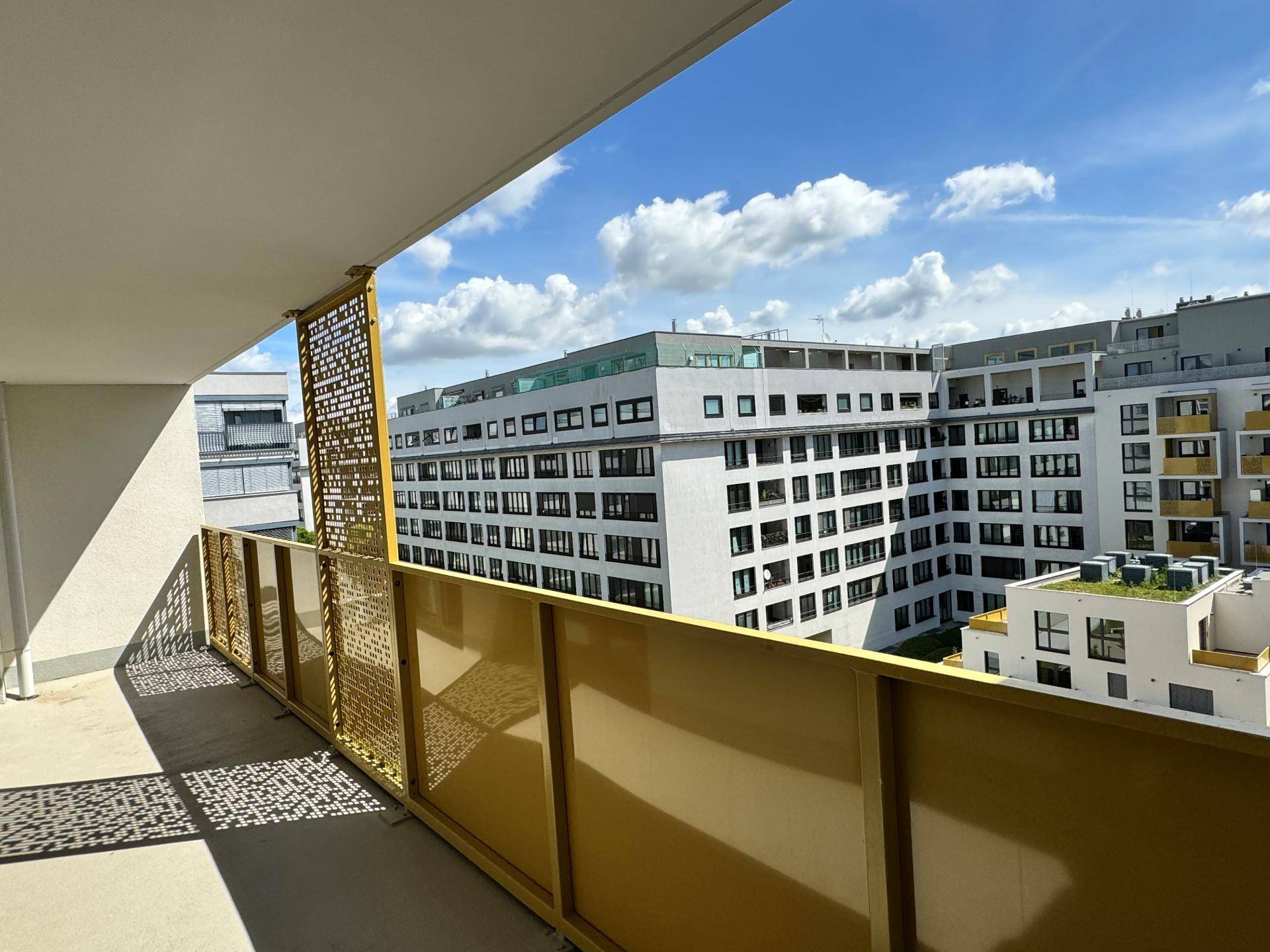 Geräumiger Balkon mit moderner Brüstung und Blick auf die umliegenden Gebäude.