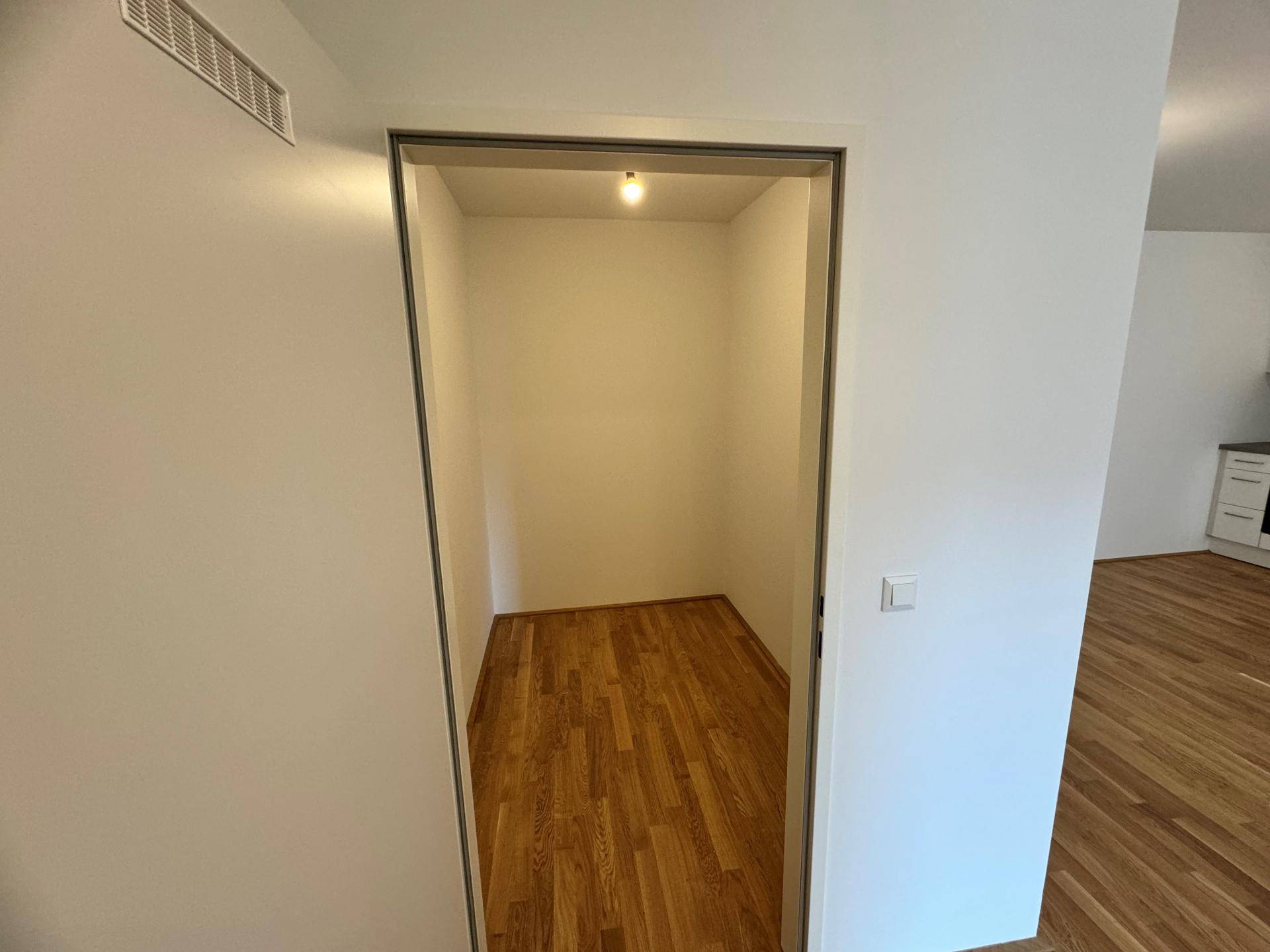 Praktischer Abstellraum mit Holzboden und ausreichend Platz für Lagerung.