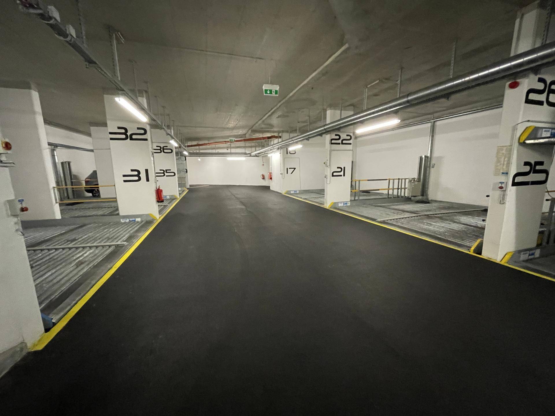 Geräumige Tiefgarage mit mehreren Doppelparkern und klar gekennzeichneten Stellplätzen für Bewohner.