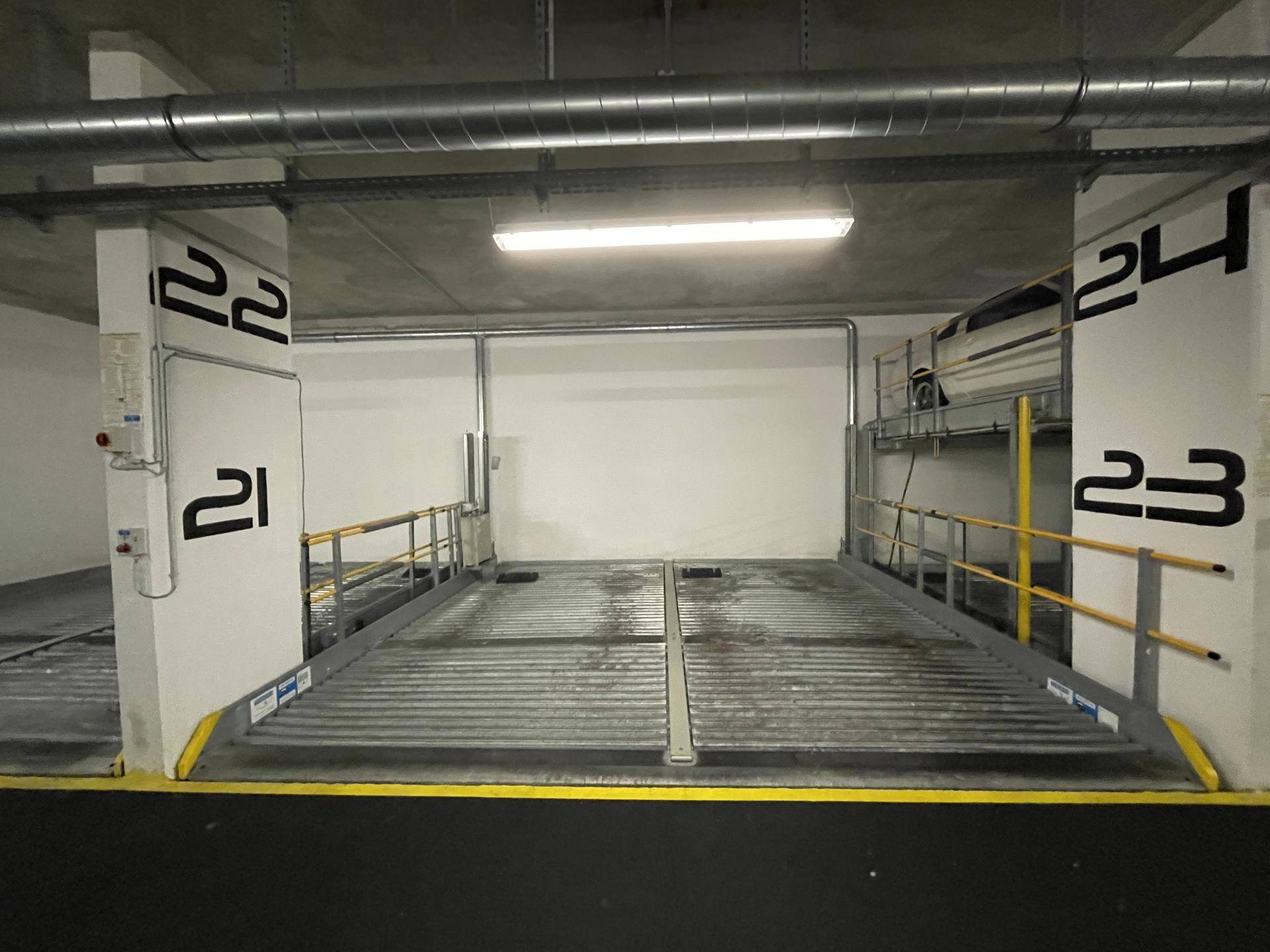Moderner Tiefgaragenstellplatz mit mechanischem Parksystem für effiziente Raumnutzung und nummerierten Plätzen.