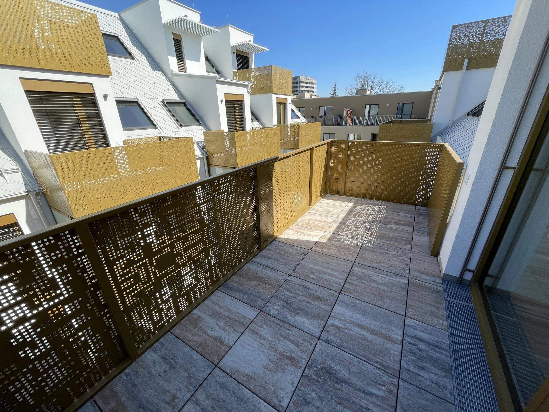 Geräumiger Balkon mit modernen Fliesen und dekorativen Metallgeländern, bietet Platz im Freien.