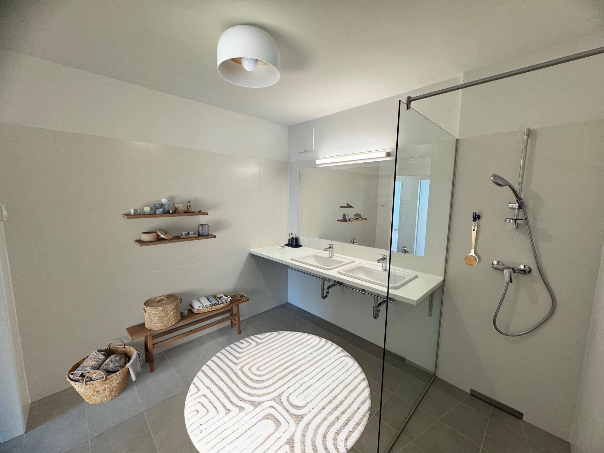 Modernes Badezimmer mit Doppelwaschbecken, großer Dusche und hellen Fliesen.