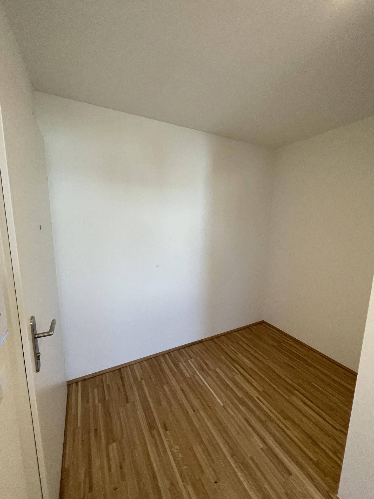 Kleiner Abstellraum mit Parkettboden und weißen Wänden, ideal für zusätzlichen Stauraum.