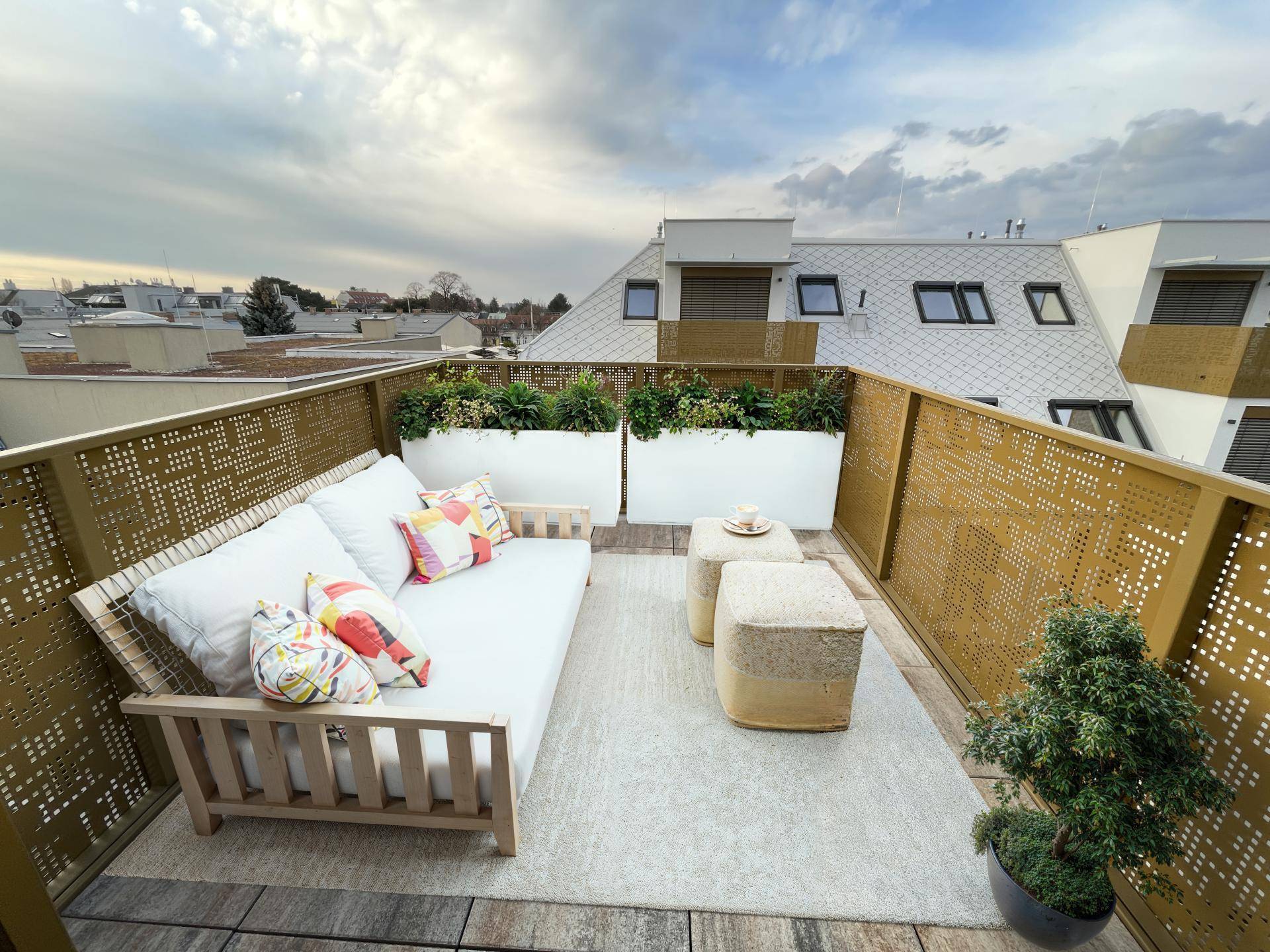 Gemütliche Dachterrasse mit bequemen Outdoor-Möbeln und Pflanzen, ideal zum Entspannen.