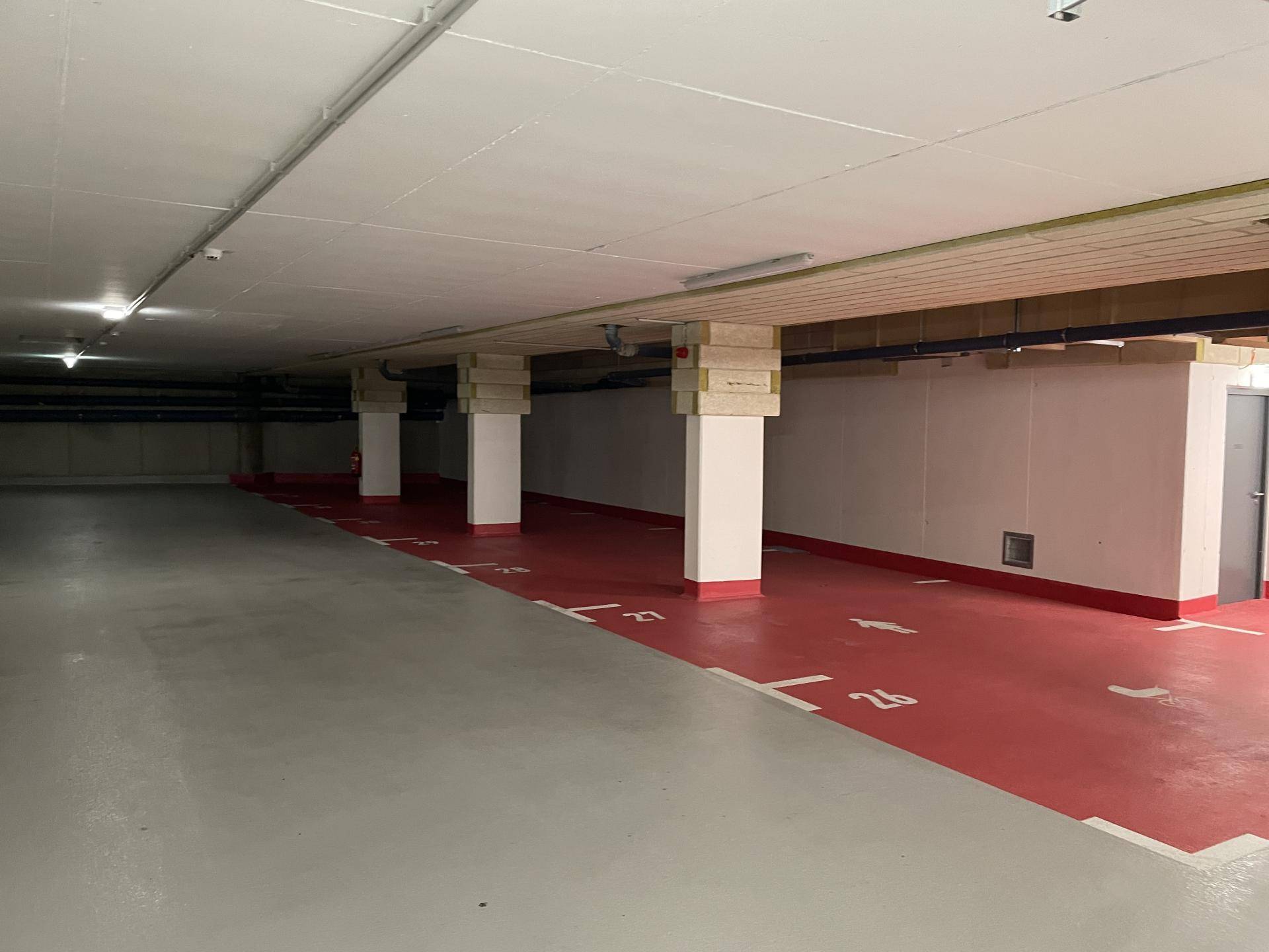 Geräumige Tiefgarage mit zahlreichen markierten Stellplätzen und Säulen.