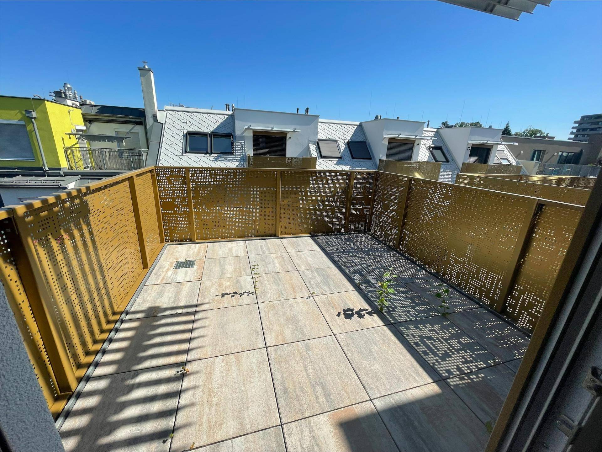 Dachterrasse mit dekorativen Metallgeländern und Fliesenboden, bietet einen sonnigen Außenbereich.
