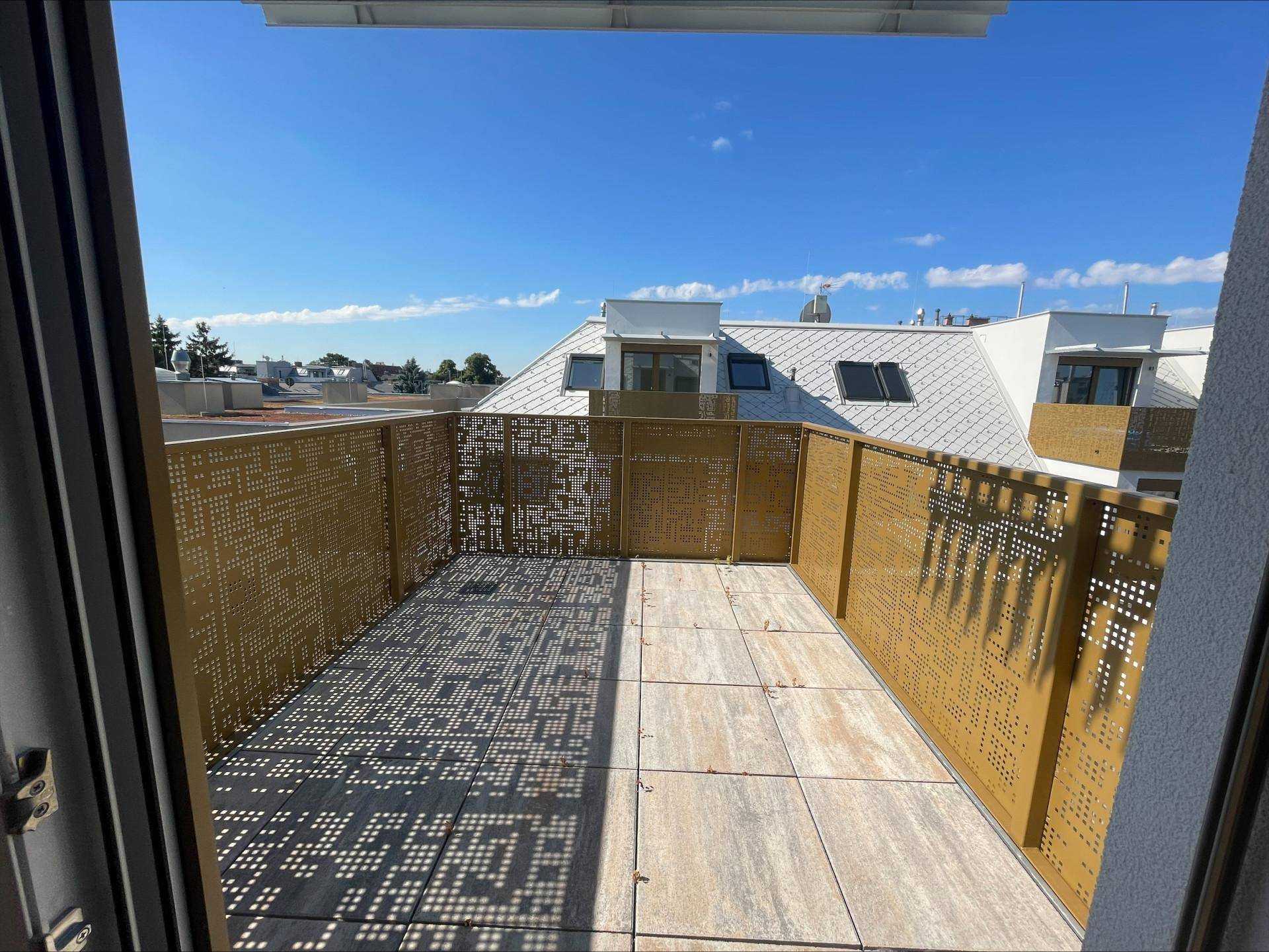 Geräumige Dachterrasse mit modernen Fliesen und dekorativen Metallgeländern, bietet einen weiten Blick.