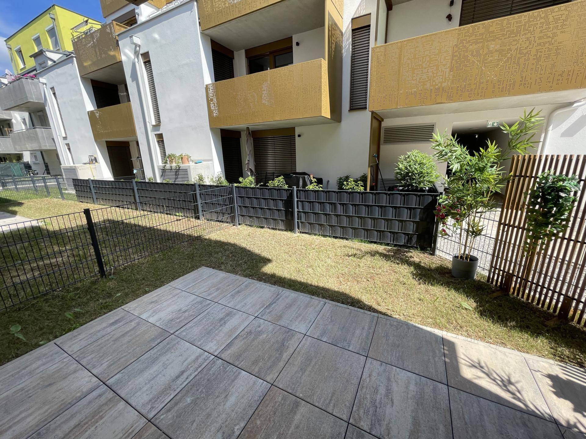 Gepflegter Gartenbereich mit kleiner Terrasse und Sichtschutz zum Nachbargrundstück.
