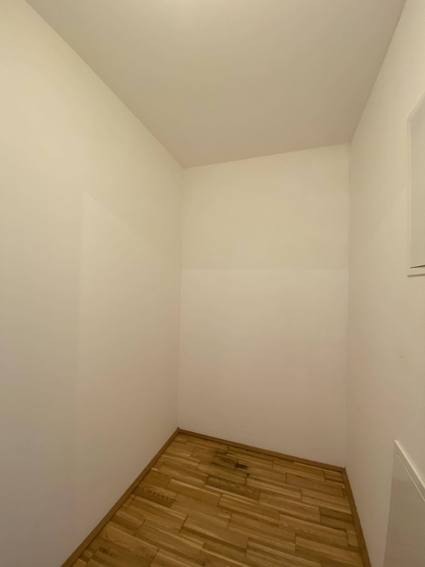 Kleiner, leerer Raum mit Parkettboden, ideal als Abstellraum oder begehbarer Kleiderschrank.