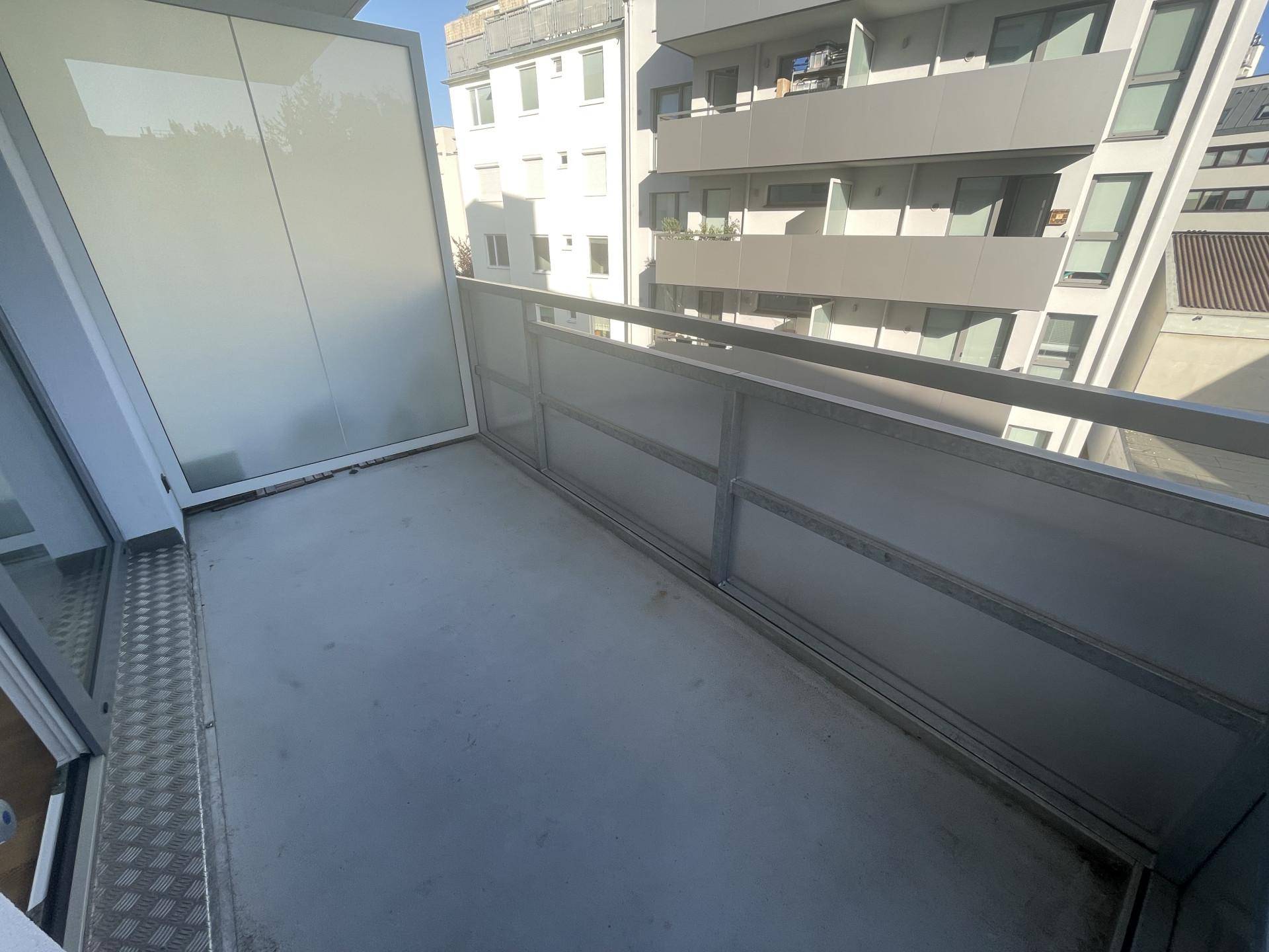 Leerer Balkon mit Betonboden und Metallgeländer, bereit zur individuellen Gestaltung.