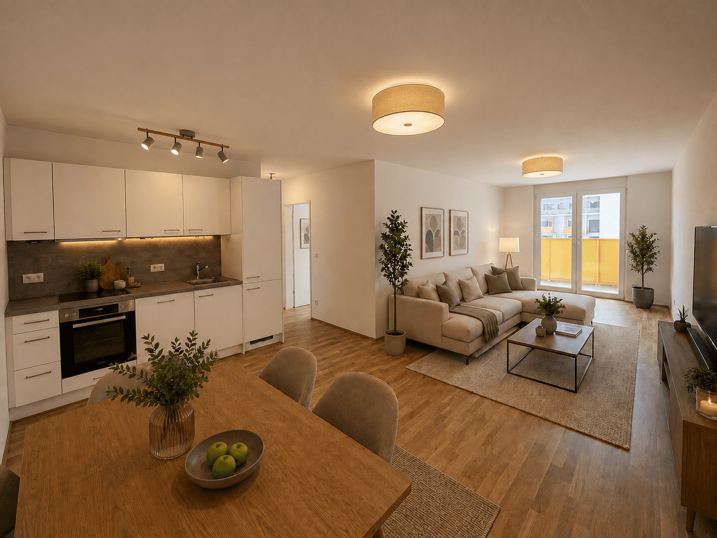 Heller offener Wohn-Essbereich mit integrierter Küche, Holzboden und Zugang zum Balkon.