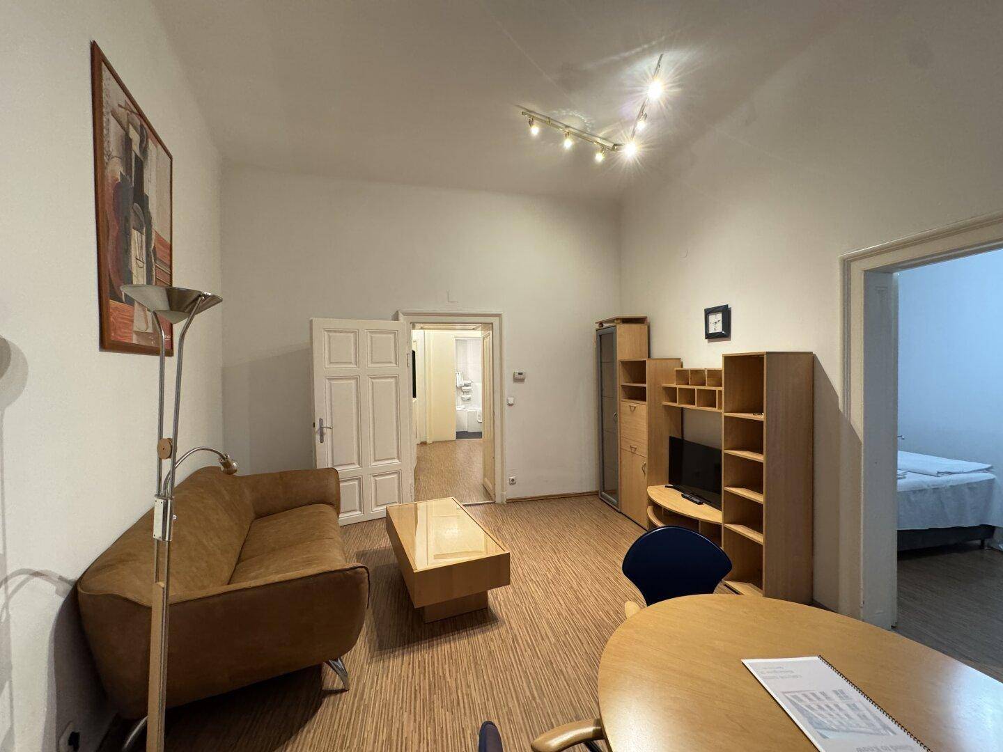 Geräumiger Wohnbereich mit Couch, Couchtisch und Blick auf angrenzende Zimmer.