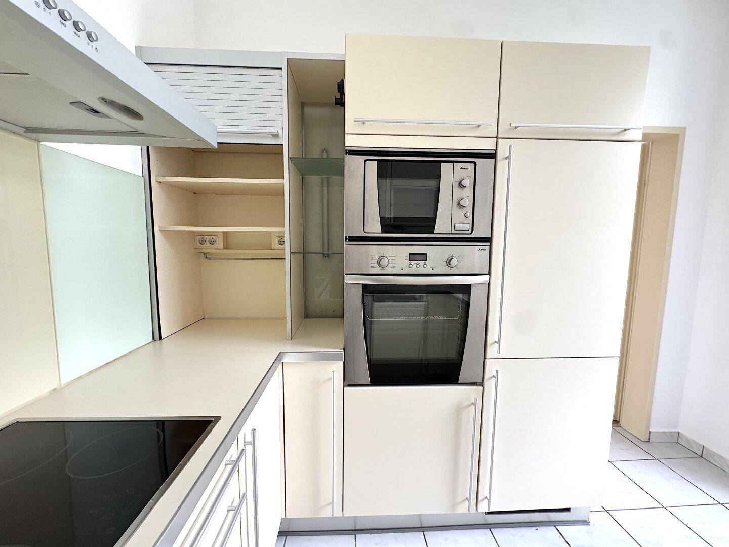 Küche mit integriertem Backofen, Mikrowelle und praktischen Staufächern.