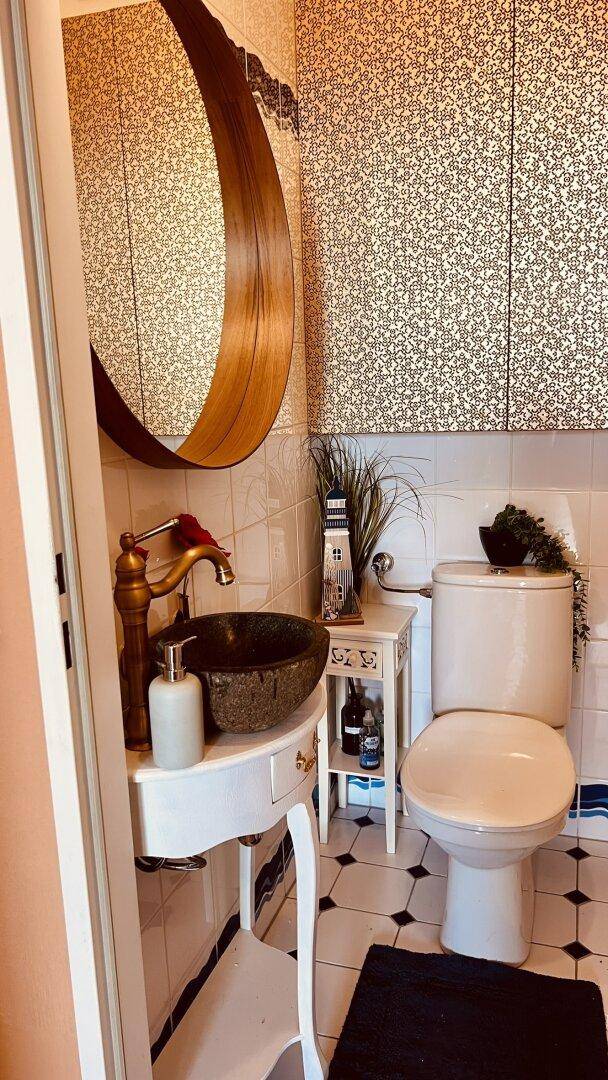 Stilvolles Gäste-WC mit einzigartigem Waschbecken, Toilette und gemusterten Wänden.
