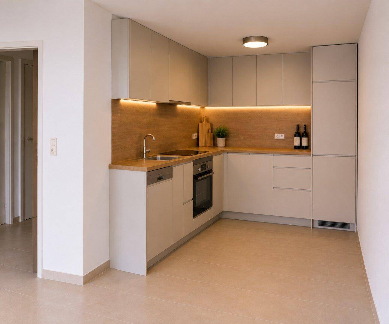 Moderne Einbauküche mit hellgrauen Fronten, Holzakzenten und integrierten Geräten.