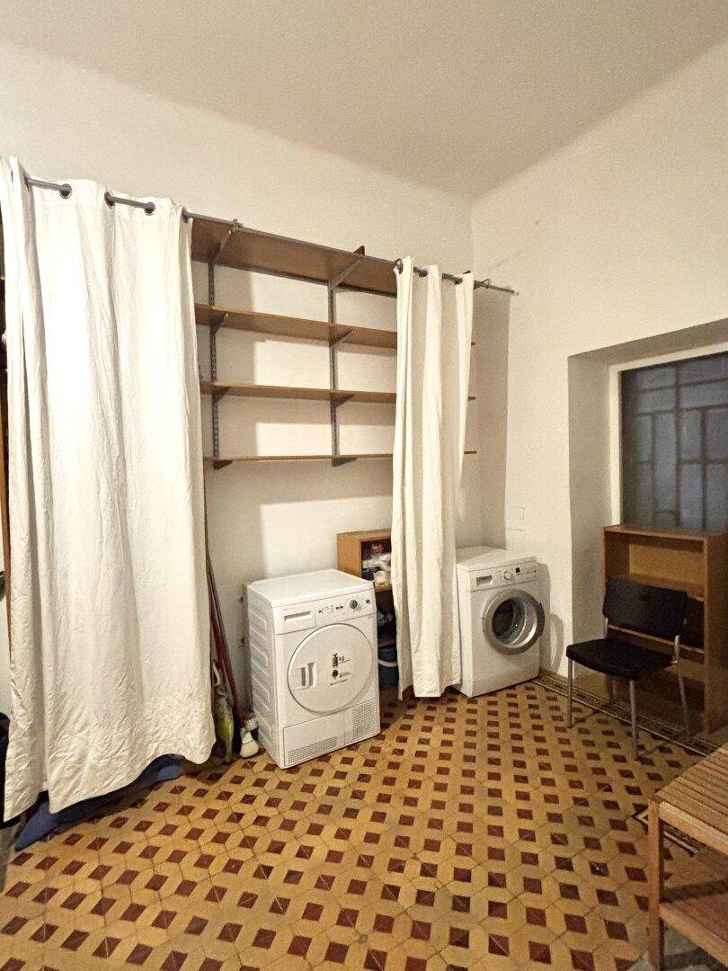 Praktischer Hauswirtschaftsraum mit Waschmaschine, Trockner und Regalsystem für zusätzlichen Stauraum.