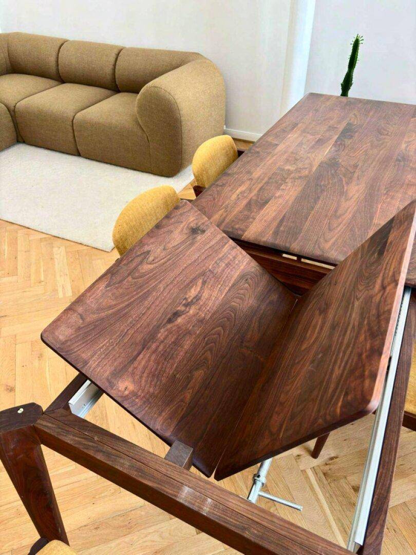 Detailaufnahme des ausziehbaren Esstisches aus dunklem Holz im modernen Essbereich mit Parkettboden.