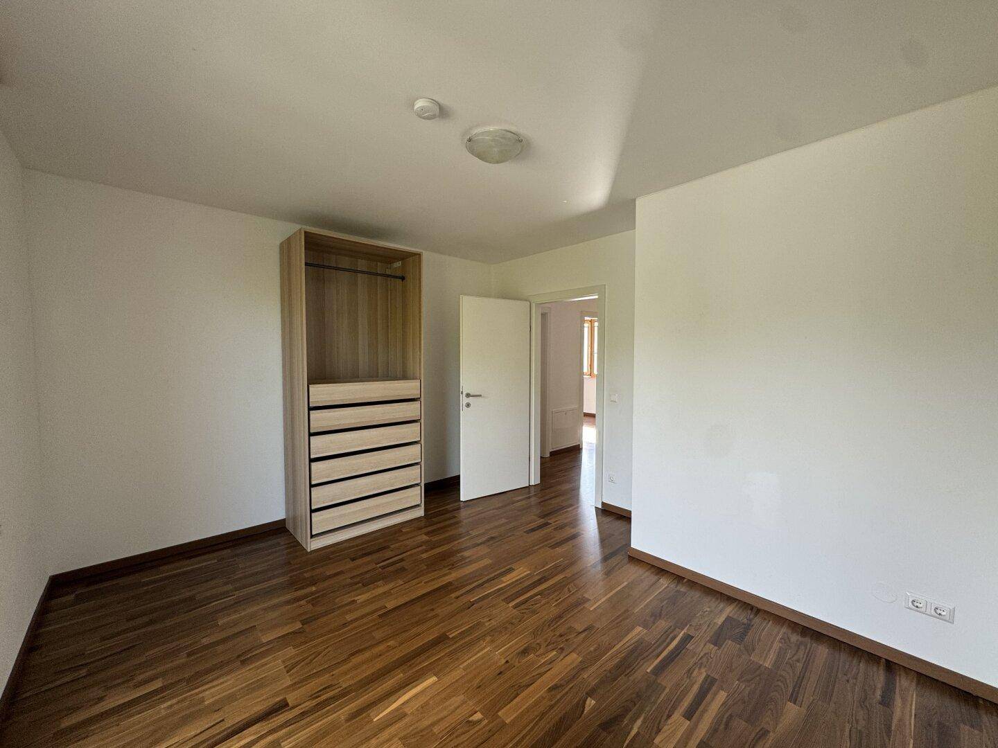 Schlafzimmer mit Holzboden und praktischem Kleiderschrank, bereit zur Einrichtung.