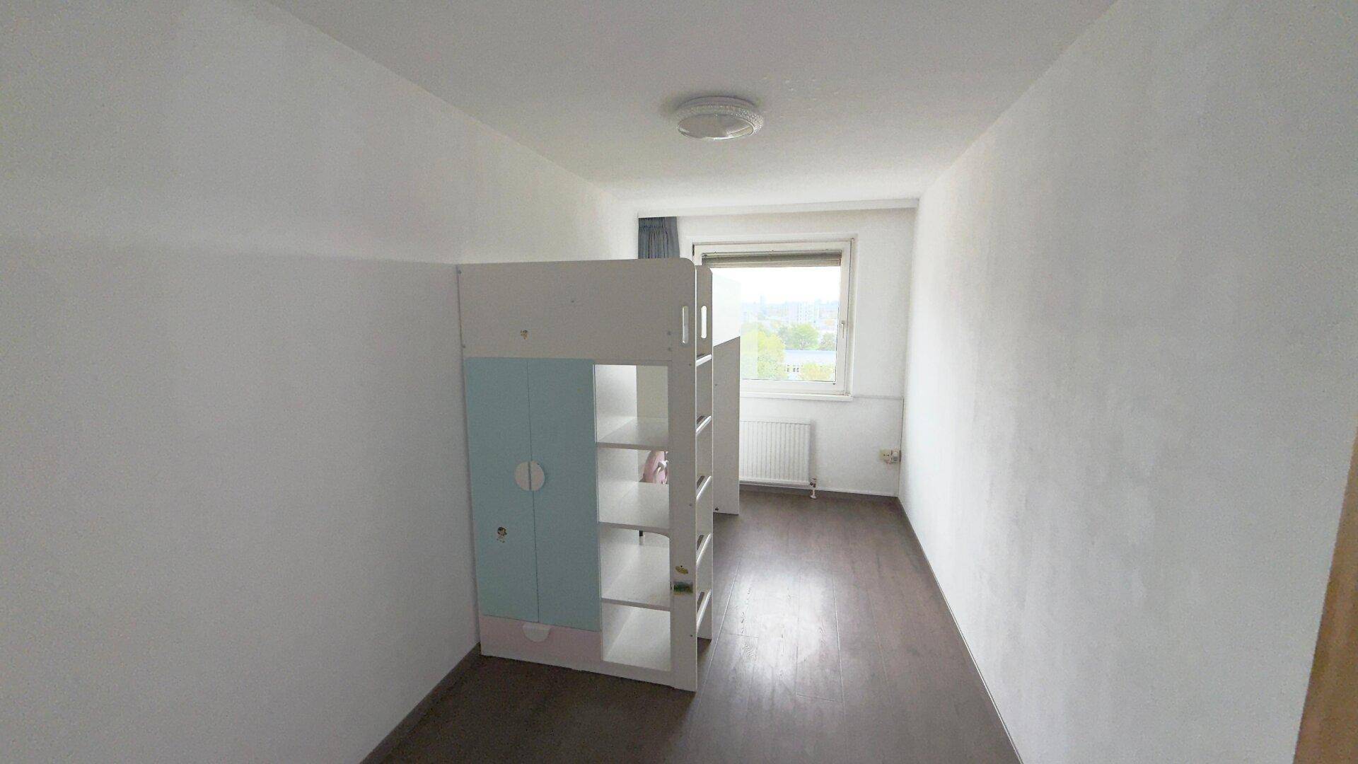 Kinderzimmer oder Gästezimmer mit Fenster, Heizkörper und einem Hochbettgestell, ausgestattet mit Laminatboden.