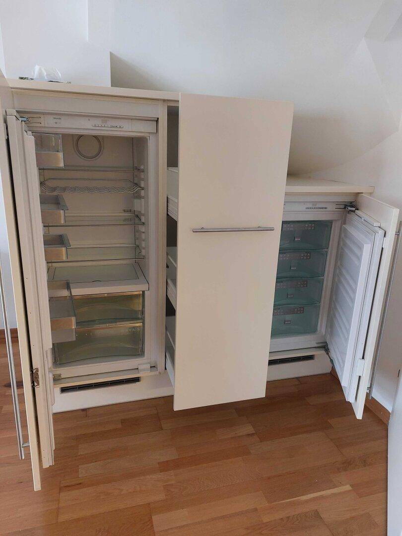 Integrierter Kühlschrank und Gefrierschrank in weißer Ausführung, passend zur Kücheneinrichtung.