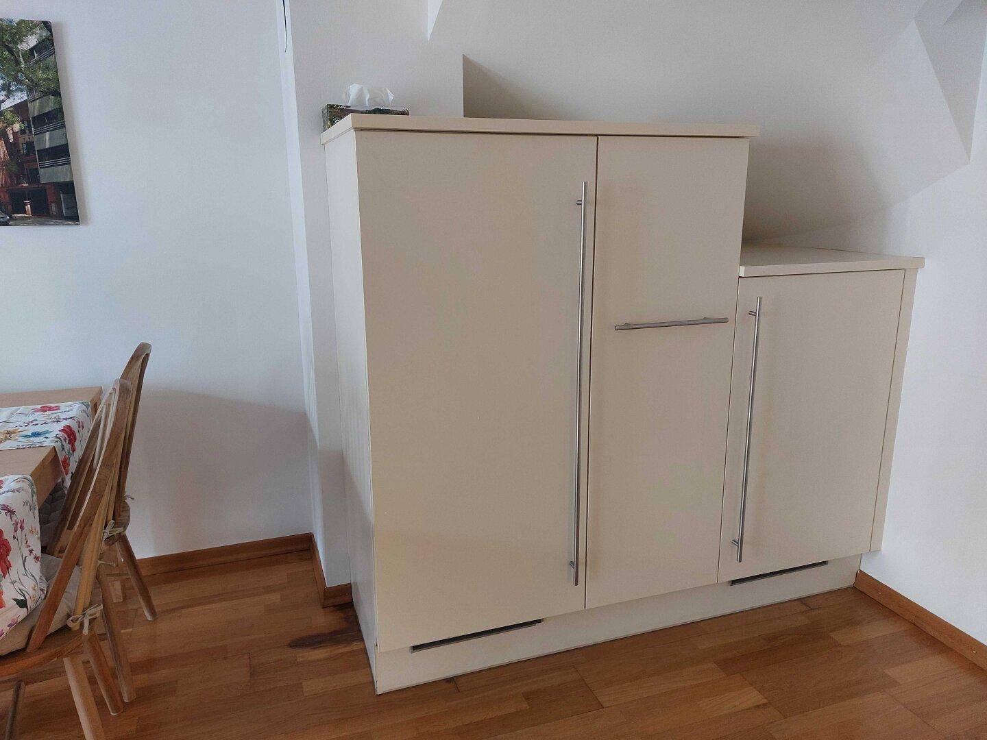Weiße Einbauschränke mit modernen Griffen bieten zusätzlichen Stauraum im Wohnbereich.