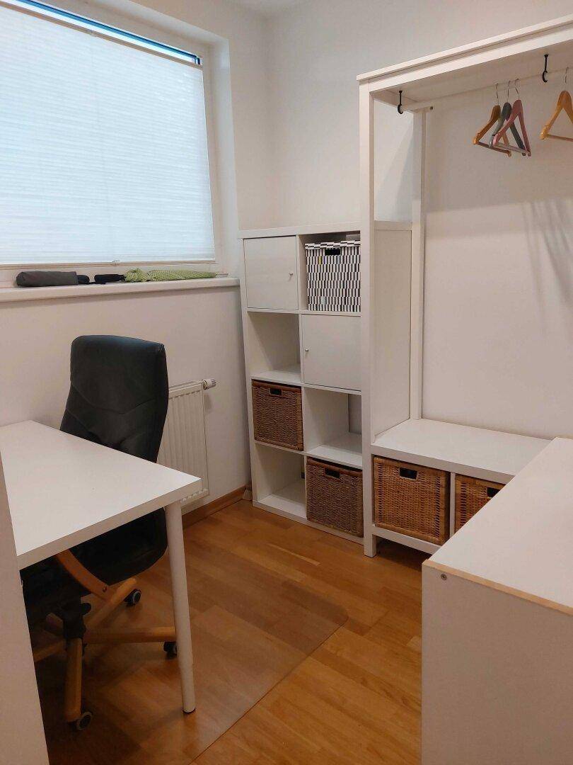 Funktionales Arbeitszimmer mit Schreibtisch, Bürostuhl und praktischen Regalen für Stauraum.