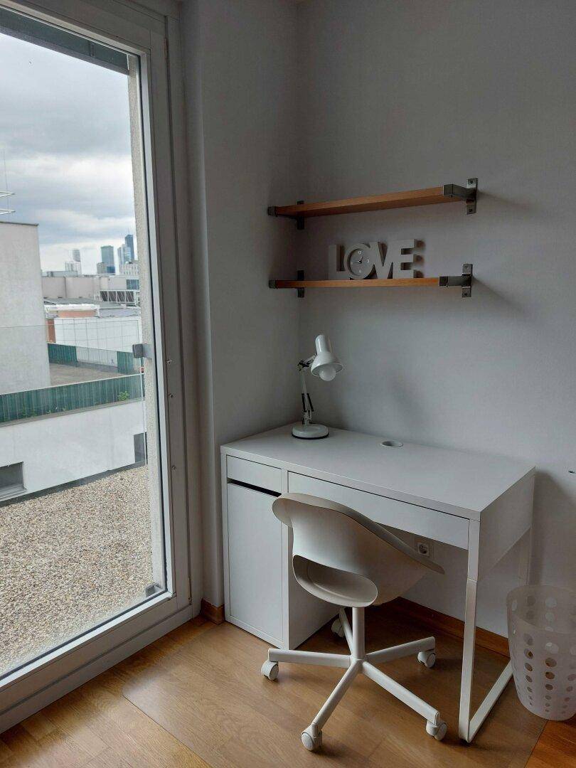 Helles Arbeitszimmer mit Schreibtisch und Stuhl, bietet einen weiten Blick aus dem Fenster.