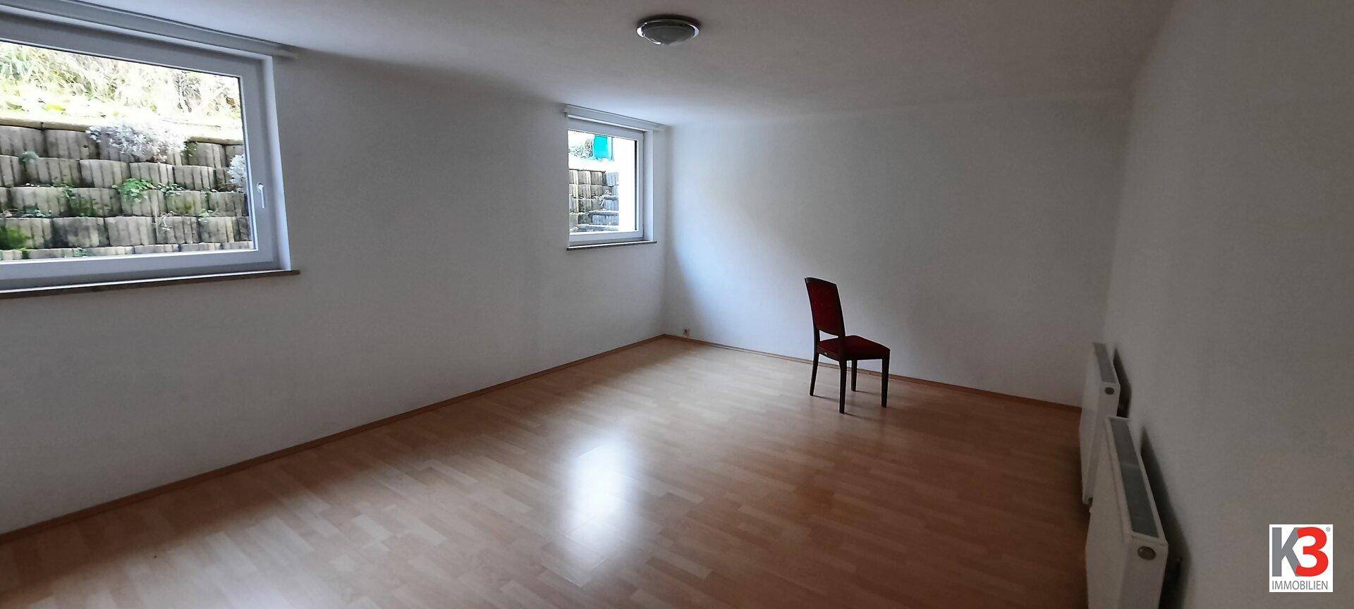 Heller Kellerraum mit Laminatboden und Fenster, ideal als Hobby- oder Abstellraum.