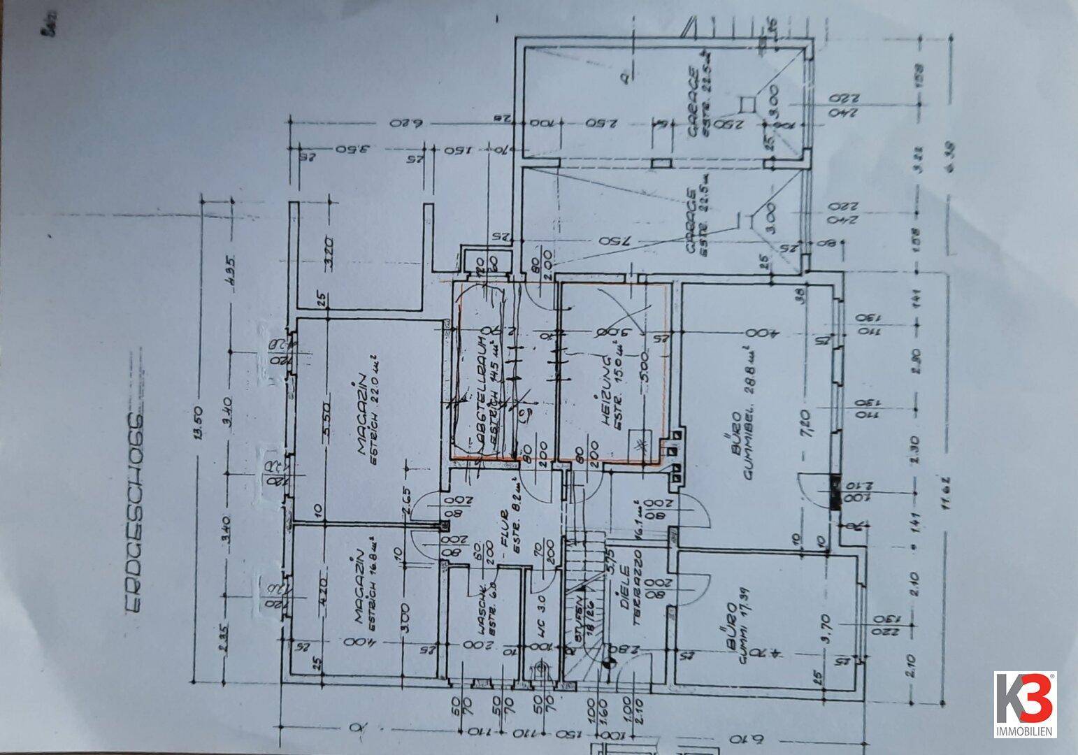 Grundriss des Erdgeschosses mit Büros, Küche, Bad und integrierter Garage.