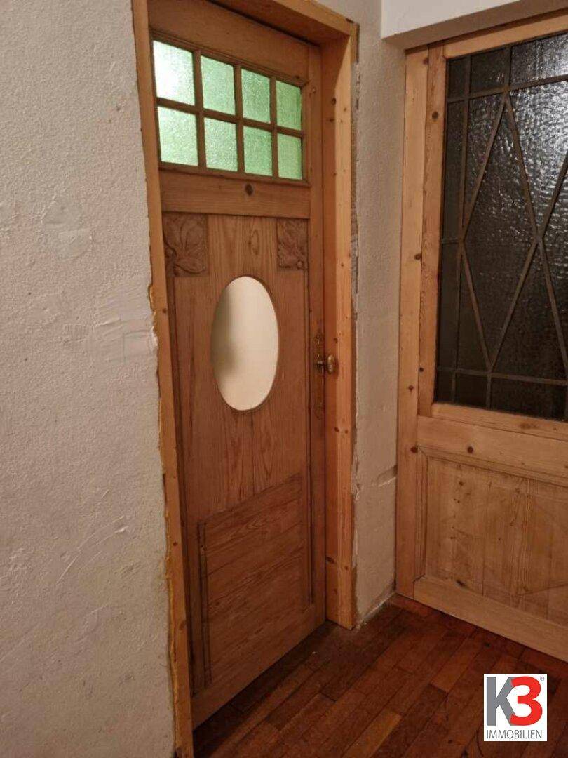 Rustikale Holztüren mit verzierten Glaseinsätzen und traditionellem Design.