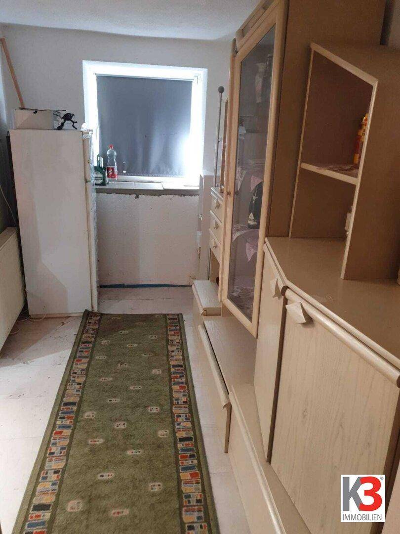 Innenraum mit Schrankmöbeln, Kühlschrank und einem Fenster.