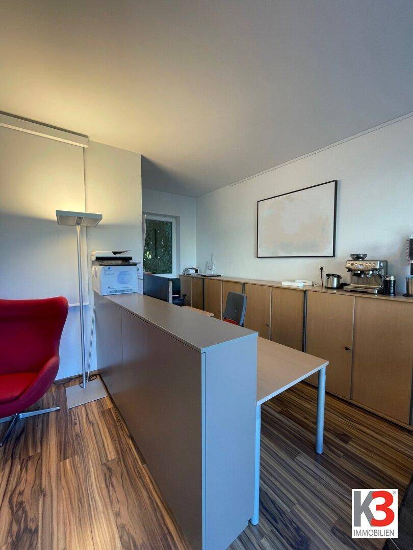 Funktionaler Bürobereich mit Schreibtisch, Stauraum und Blick ins Grüne, ideal für konzentriertes Arbeiten.