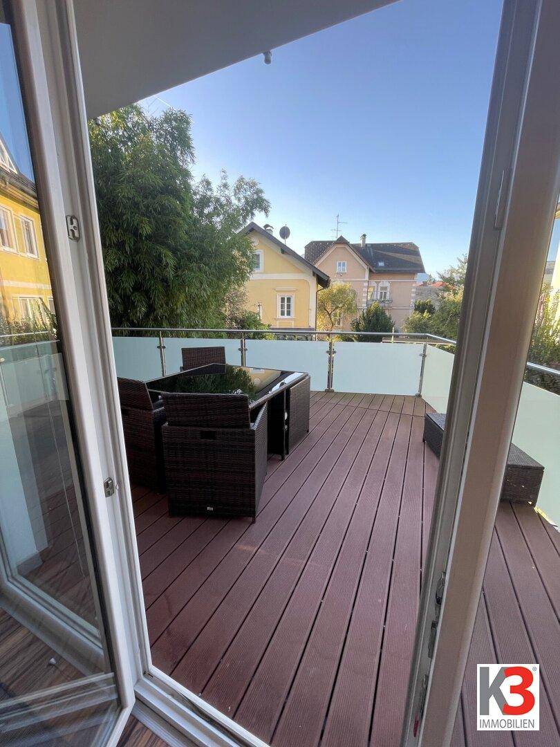 Geräumiger Balkon mit modernen Outdoor-Möbeln und Blick auf die Nachbarschaft.