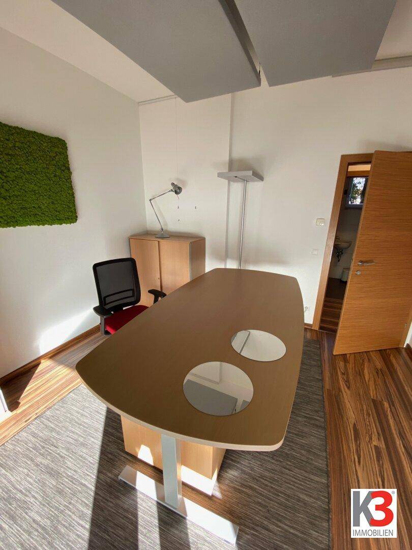Modernes Büro mit ergonomischem Schreibtisch und Stuhl, gut beleuchtet.