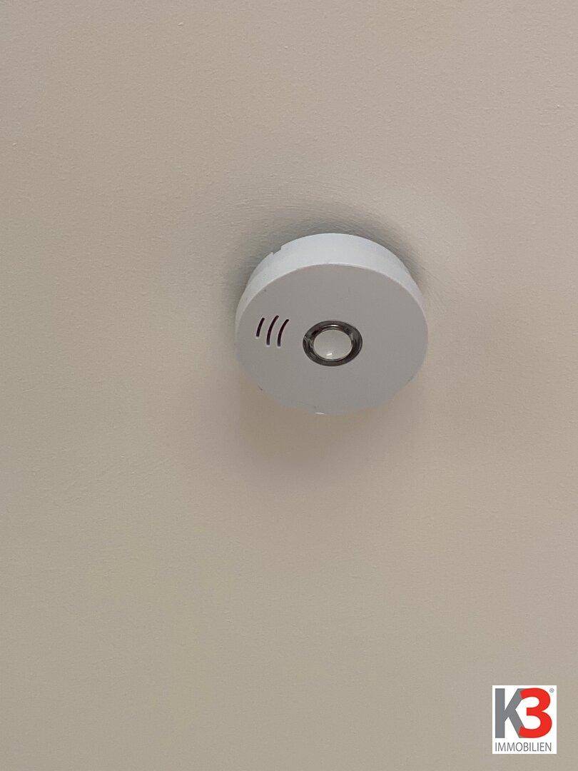 Rauchmelder an der Decke, ein wichtiges Sicherheitsmerkmal im Innenbereich.