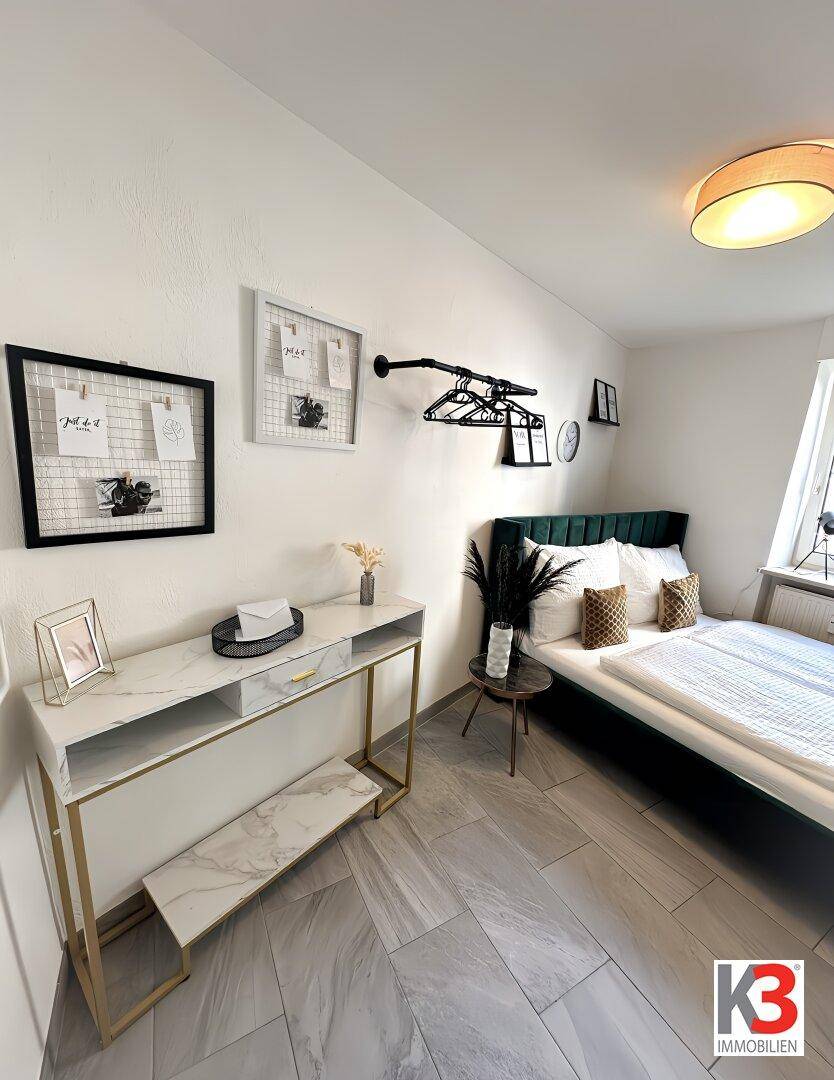 Helles Schlafzimmer mit modernem Bett, stilvollem Konsolentisch und offener Kleiderstange.