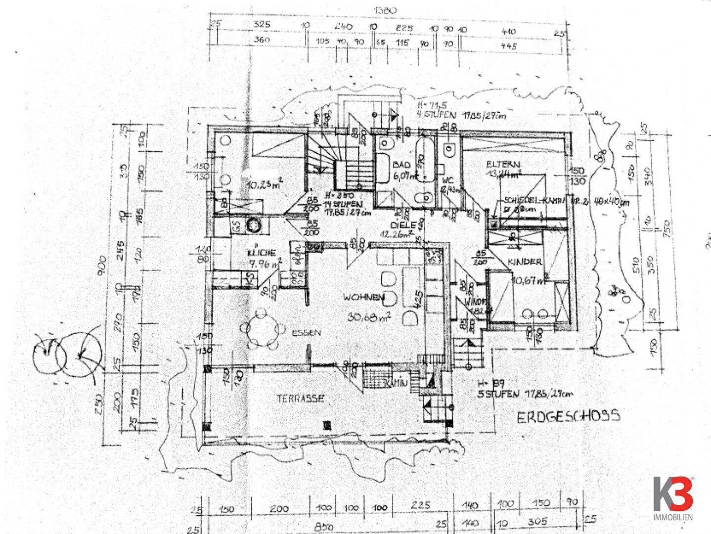 Grundriss des Erdgeschosses mit offenem Wohnbereich, Küche, Terrasse und Garten.