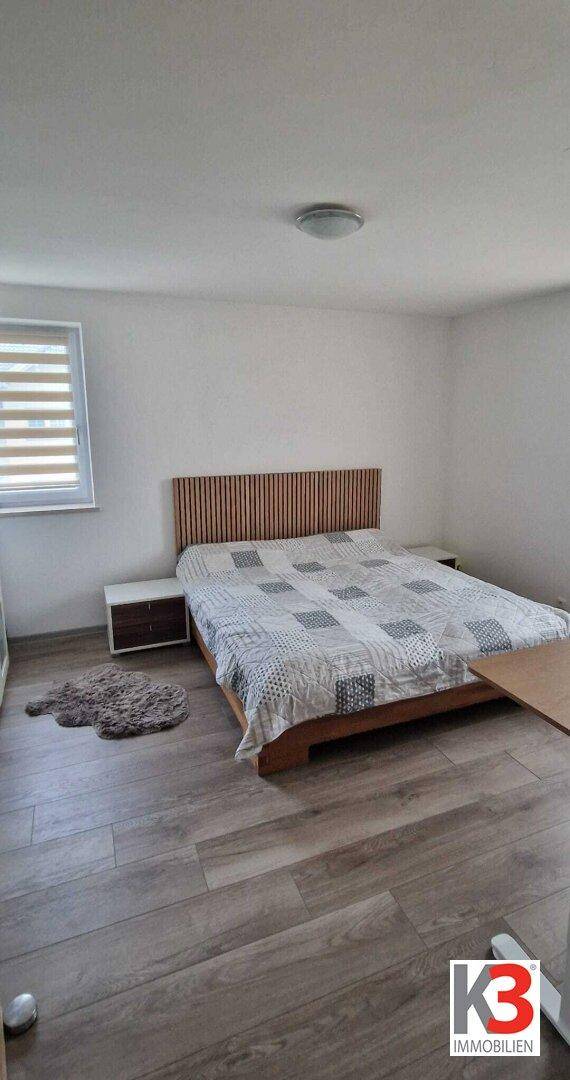Schlafzimmer mit Holzbett, Nachttischen und Holzboden, bietet eine ruhige Atmosphäre.