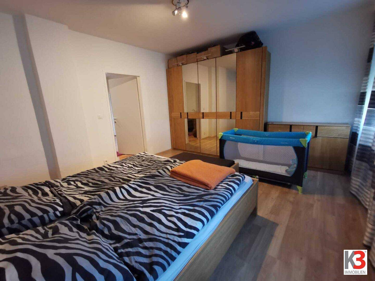 Das Schlafzimmer mit Doppelbett, Babybett und großem Kleiderschrank.