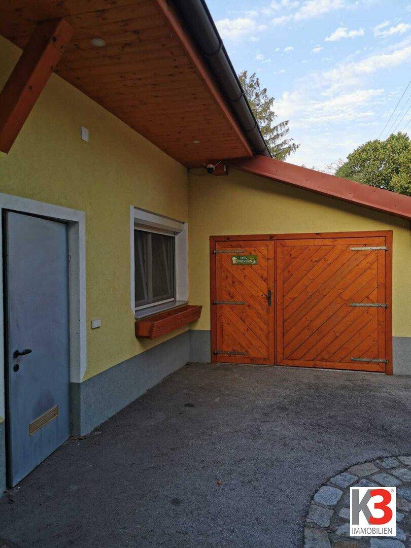 Die Seite des Hauses mit rustikalen Holztoren und einer Eingangstür.