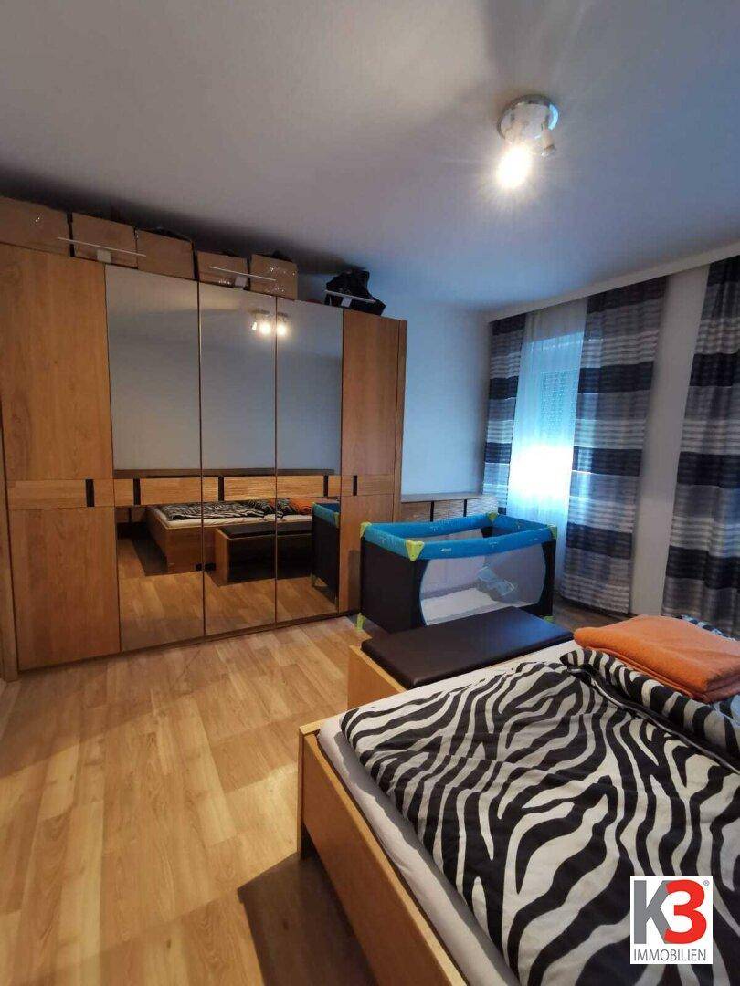 Das Schlafzimmer mit großem Spiegelschrank, Doppelbett und Babybett.