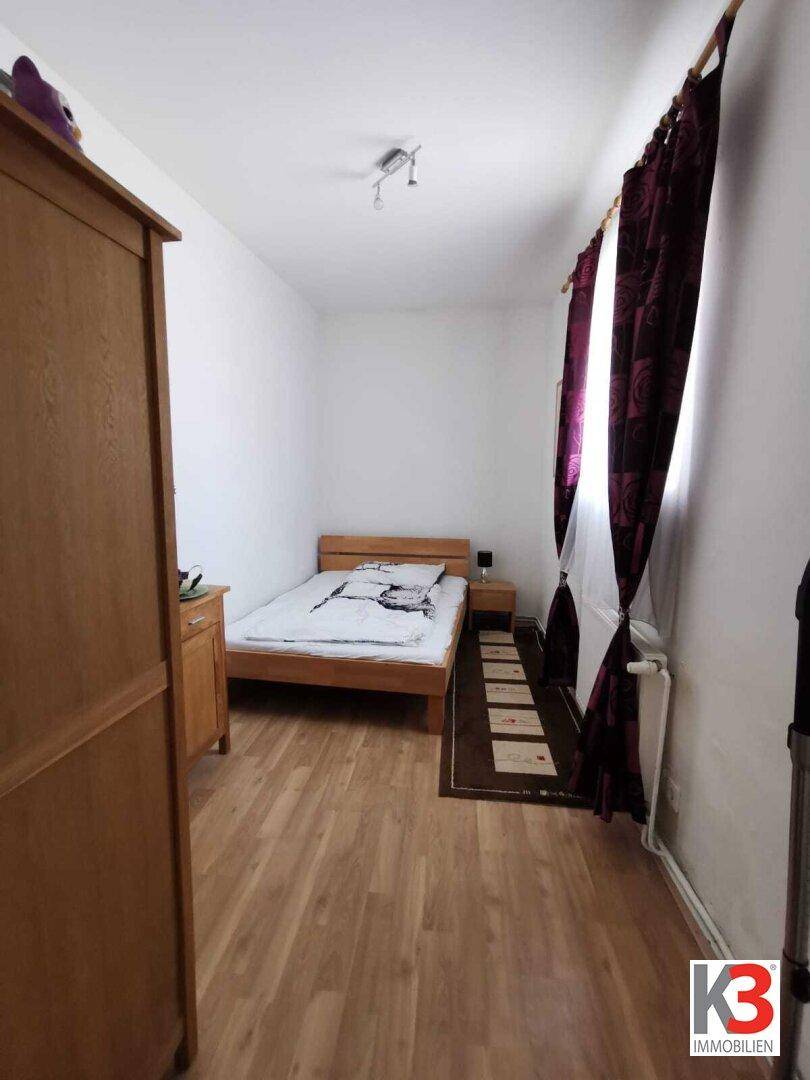 Das Schlafzimmer mit Einzelbett, Holzschrank und Holzboden.