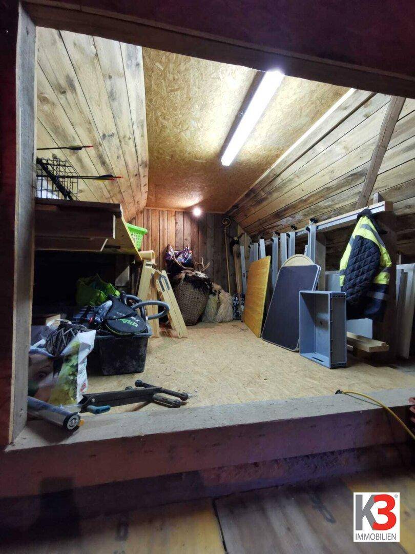 Der Dachboden als Abstellraum mit Holzfußboden, Dachschrägen und sichtbaren Balken.