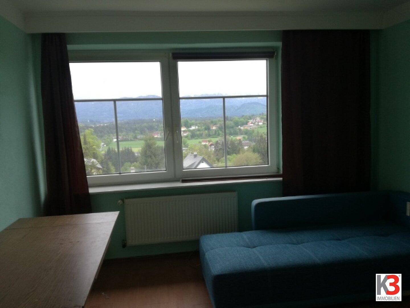 Schlafzimmer mit Sofa und Schreibtisch, bietet einen weiten Blick auf die umliegende Landschaft.