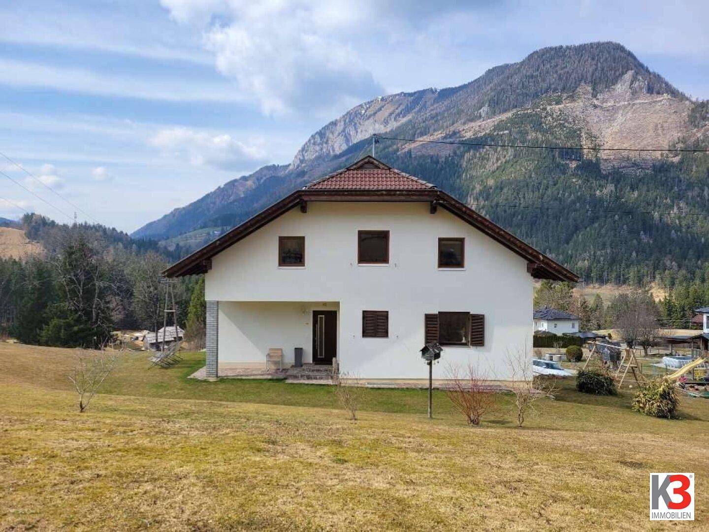 Freistehendes Einfamilienhaus mit Satteldach und weitem Blick auf die umliegenden Berge.